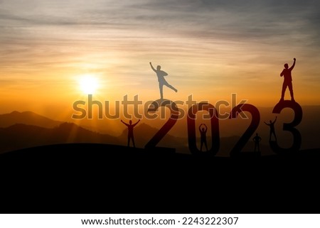 Man raise two hand success happy new year 2023 concept, silhouette of man jumping over barrier cliff and success with sunset background. Happy New Year 2023 use for web banner and advertisement.