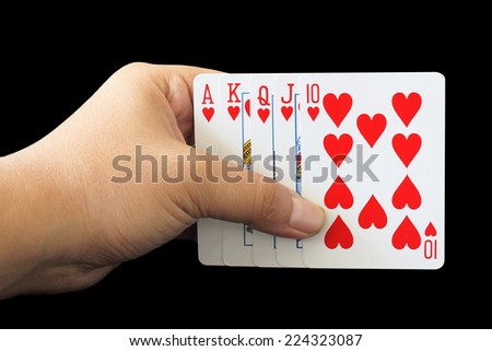 Royal Flush of heart in poker game in the hand on a black background