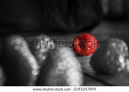 black and white photo of raspberries with color editing