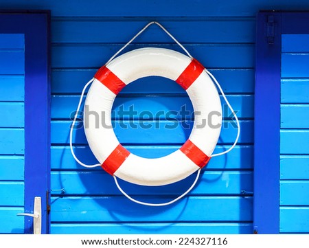 White flotation ring on the blue wall near boat rental Royalty-Free Stock Photo #224327116
