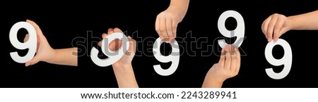 Number nine in hand isolated on black background. Number 9 in a child's hand is held on a black background. A large set of hands with the number nine to insert into a project or design