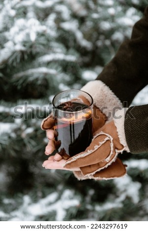 Person holding mulled hot wine in glass in winter