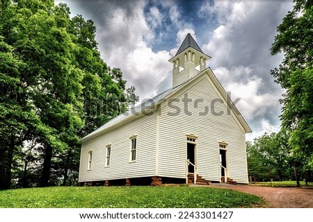 A sunny summer morning photograph of the Pioneer Methodist Church in the Cades Cove section of the Great Smoky Mountains National Park.  The Smokies are the most visited National Park. Royalty-Free Stock Photo #2243301427