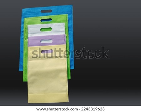 colorful non woven bags on black background. Reduce reuse recycle Bags. Few ECO friendly fabric bags. 