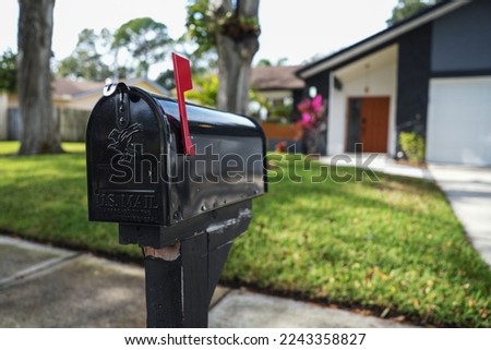 Black mailbox in front of a house Royalty-Free Stock Photo #2243358827