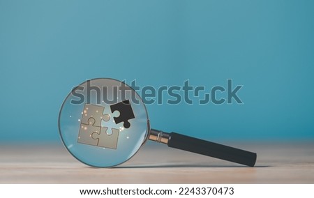 A magnifying glass is placed on the table,Idea to find a business solution,Link success with creative problem solving,and strategic planning to develop the organization into the future Royalty-Free Stock Photo #2243370473