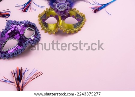 Table top view aerial image of beautiful colorful carnival festival background.Flat lay accessory object the several mask  decor confetti on modern pink paper at home office desk studio.copy space.
