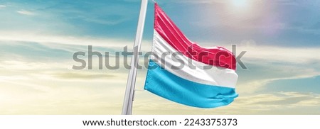 Luxembourg Flag on pole for Independence day. The symbol of the state on wavy cotton fabric.