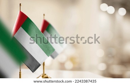 Small flags of the Arab Emirates on an abstract blurry background.