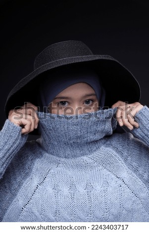 Hijab Fashion in winter season over black background.