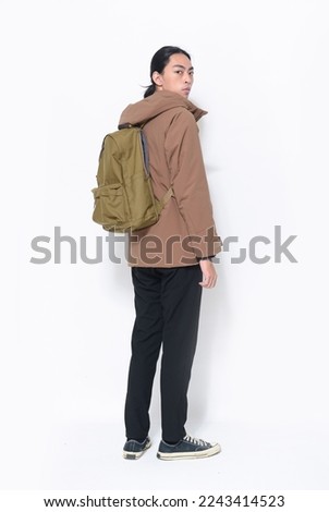 portrait of back view full body young attractive man, wearing, hoodie jacket , black pants  with backpack in studio