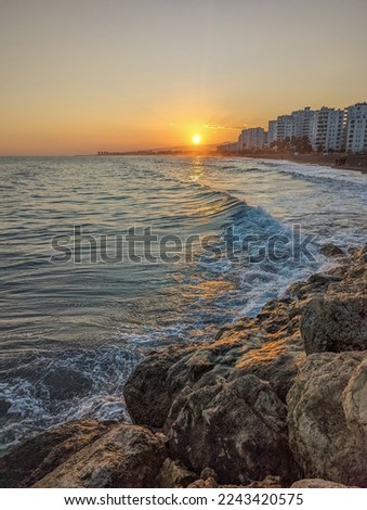Sunset on the Mediterranean Sea in Turkey. The setting sun reflects on the waves of the sea. Coast of the sea during sunset in late autumn.