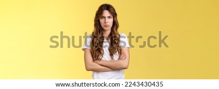 Upset jealous moody clingy girlfriend sulking offended cross hands chest blocking pose frowning disappointed complaining unfair treatment stand yellow background bothered pouting childish.