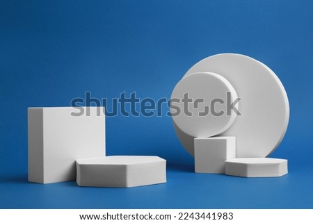 Product photography props. Podiums of different geometric shapes on blue background
