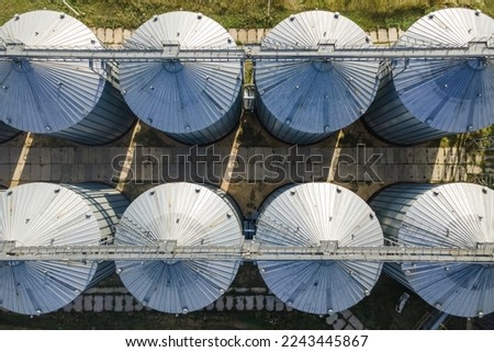 Aerial wide shot of agricultural grain silo storage tanks. Top down view
