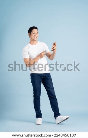 portrait of asian man posing on blue background Royalty-Free Stock Photo #2243458139