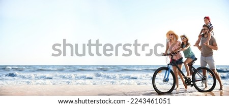Happy family with bicycle on sandy beach near sea, space for text. Banner design