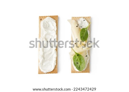 Sandwich, toast on grain crispbread with cream cheese, sliced cheese, spinach isolated on white background. Snack, bruschetta. Royalty-Free Stock Photo #2243472429