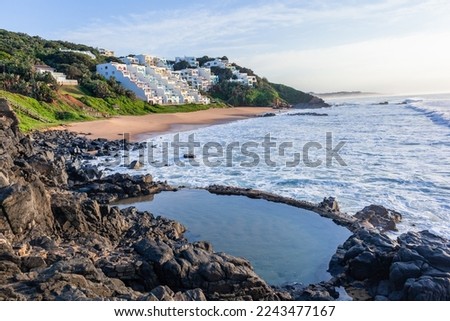 Beach's Ballito Bay coastline rocky coves for swimming surfing ocean waves with apartments houses a holiday vacation  landscape