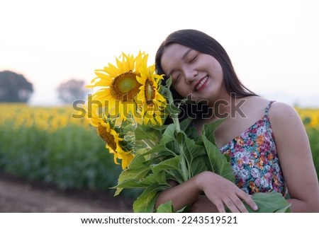 Closeup picture beautiful young girl with sunflower at flower filed in the morning.