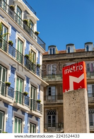 The red "M" signs to show the entrance to the Lisbon Metro stations,set against a blue sky in Portugal.