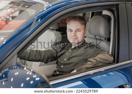 man buys car from dealership, happy confident businessman chooses blue automobile. purchase of property and signing of the leasing trade in contract.