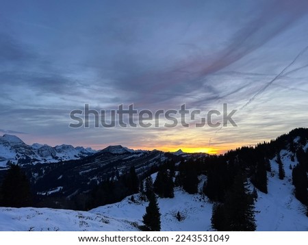 Magical sunset and shy sun behind winter clouds over the Obertoggenburg region and in the Swiss Prealps, Urnäsch (Urnaesch or Urnasch) - Canton of Appenzell Innerrhoden, Switzerland (Schweiz)