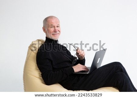 An elderly man is shopping online. The concept of online communication. The concept of the lifestyle of the elderly, computer technology, retirement holidays. High quality photo