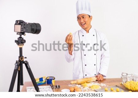 male chef food vlogger presenting cake to camera while baking cake with isolated background