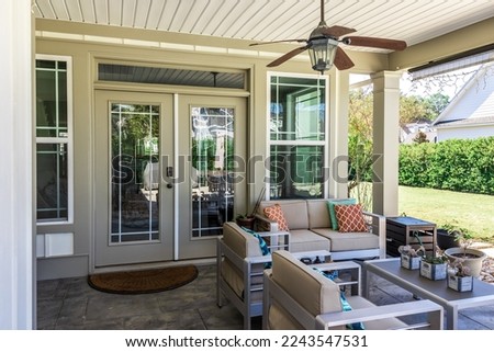 Covered outdoor patio in a new construction house home with guest seating.