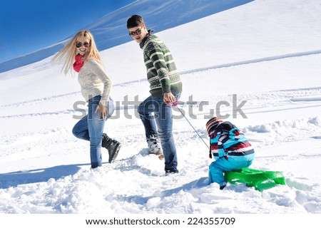 Winter season. Happy family having fun on fresh snow on vacation