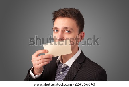 Businessman holding white card at front of her lips with copy space on gradient background