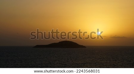 island in mediterranean sea in orange sunset.
