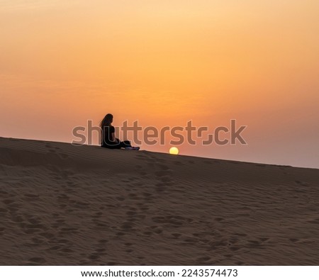 Silhouette of a woman in the desert during sunset