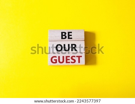 Be our guest symbol. Concept word Be our guest on wooden blocks. Beautiful yellow background. Business and Be our guest concept. Copy space