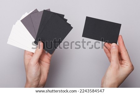 Women's hands
holding Many blank business cards for branding on gray background. Mockup for presentations and corporate identity