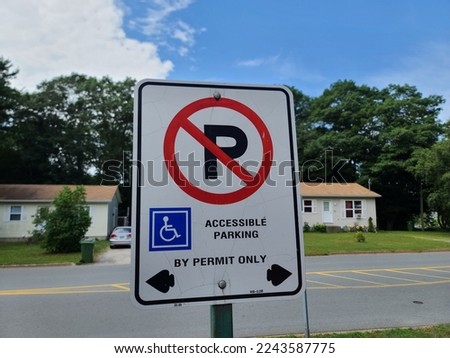 A sign indicating who is allowed to park and for how long. It says no parking, handicap accessible parking in the direction the arrow is pointing.