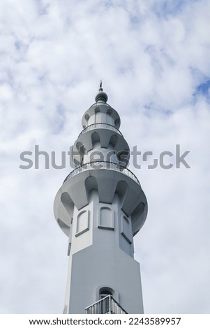 a mosque tower with a unique architecture clad in white throughout
