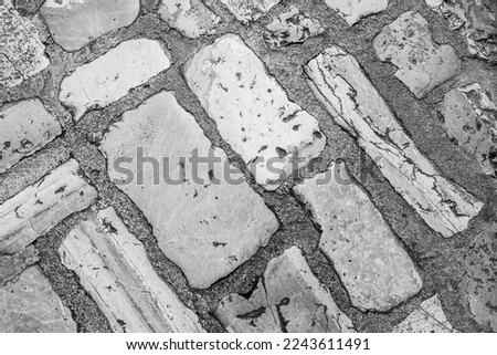 Cobblestone tiles street with big stones, top view. Ancient stone floor texture. Old pavement for a poster, calendar, post, screensaver, wallpaper, postcard, cover, website. High quality photography