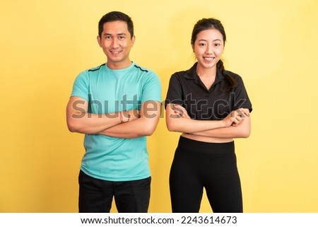 smiling asian woman and man standing with hands crossed on isolated background Royalty-Free Stock Photo #2243614673