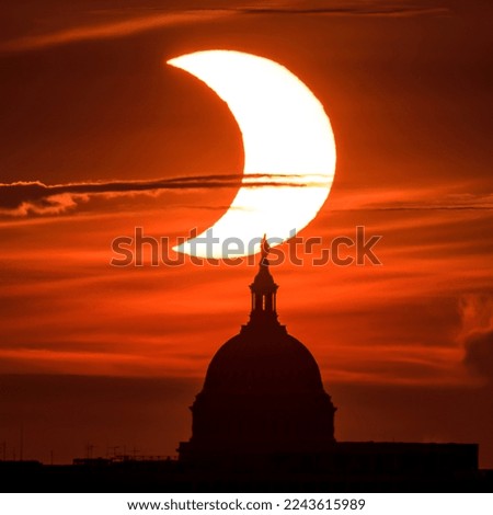 A partial solar eclipse. The Sun rising behind the United States Capitol Building. This  was an annular or ring of fire eclipse. Digitally enhanced. Elements of this image furnished by NASA.