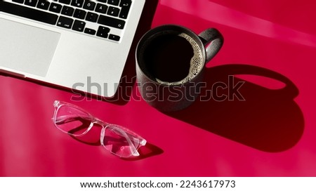 flat lay composition of notebook, coffee, computer and glasses on magenta background 