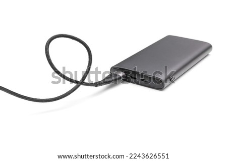 Fully charged portable powerbank with cable and two usb outputs isolated on a white background. Powerbank for charging mobile devices. Royalty-Free Stock Photo #2243626551