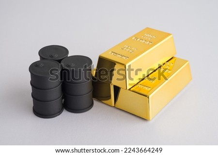 Black crude oil tanks vs gold bars on white background copy space. Commodity trading, investment, risk management, invest trategy plan, relationship between gold and oil price concept. Royalty-Free Stock Photo #2243664249