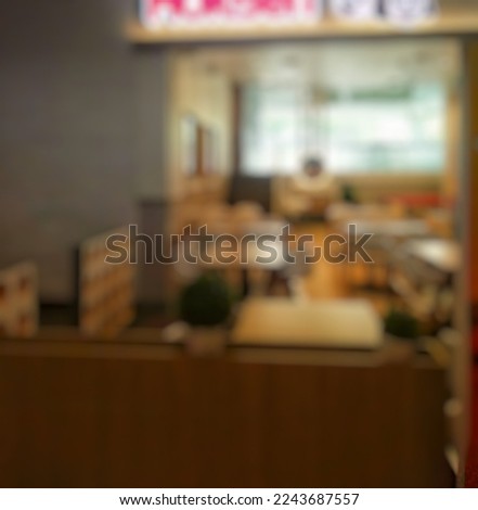 Abstract blurred Fast Food restaurant background. Blurry front view of restaurant with wooden dining tables, chairs and other decorations. Blur dark Vintage tone effect backdrop.