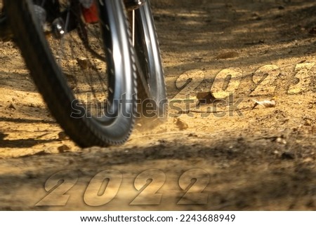 3D number 2022 and 2023  illustration of Blurry Bike Wheel on dirt