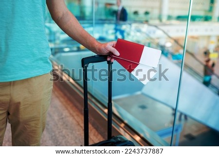Close-up of passports and boarding pass in male hands at airport Royalty-Free Stock Photo #2243737887