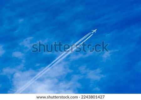 Passenger plane in the sky viewed from the ground. blue sky and clouds Royalty-Free Stock Photo #2243801427