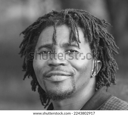 Portrait of a young man of African descent with a traditional hairstyle. Black and white photo. Royalty-Free Stock Photo #2243802917