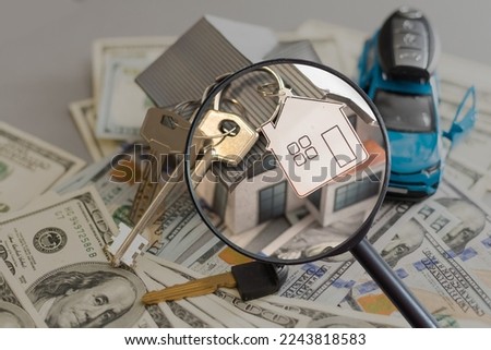 Toy model house under magnifying glass. Rent apartments, Real Estate and buying a house idea.